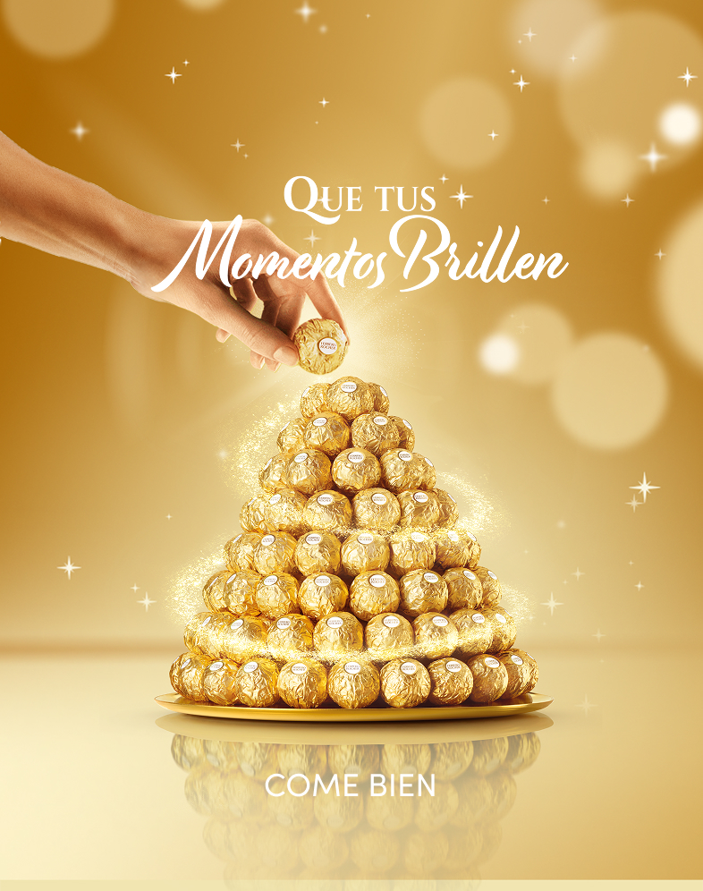 Una mano coloca un Ferrero Rocher en la cima de una pirámide de Ferrero Rocher.